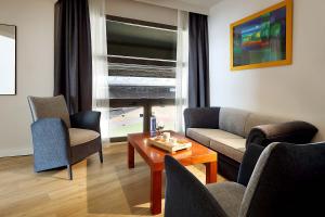 塞维利亚埃克赛卡尔图哈岛酒店的客厅配有沙发、椅子和桌子