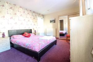 Tillicoultry布里奇旅馆的一间卧室配有一张带粉红色棉被的床