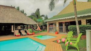 贝拉贝拉Hoogland Spa Resort Bela Bela的房屋设有游泳池、椅子和游乐场