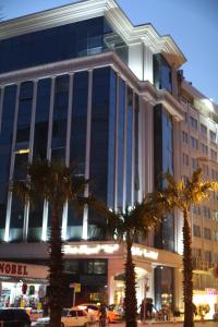 阿达纳埃米尔皇家酒店的一座棕榈树环绕的大建筑