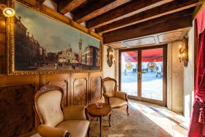 威尼斯Hotel Scandinavia - Relais的一间设有两把椅子的房间和墙上的一幅画