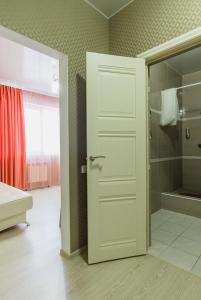 沃洛格达Guest house Sosedi的带淋浴的浴室和白色门