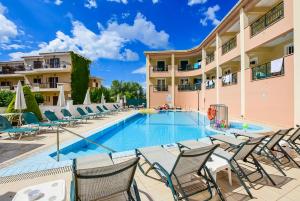 拉加纳斯Timos Hotel的一个带椅子的游泳池和一间酒店