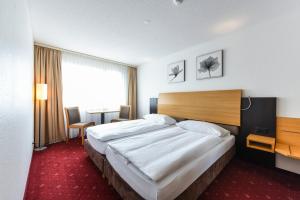 布鲁嫩城市酒店的一间卧室设有一张大床和一个大窗户