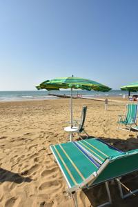利多迪耶索罗Residence Mariavittoria的海滩上的2把躺椅和1把遮阳伞