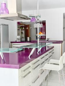 Estepona阿尔卡萨瓦海滩3302公寓的厨房配有紫色台面和白色橱柜