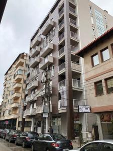 普里什蒂纳Apartment Prishtina的一座大型公寓楼,前面设有停车场