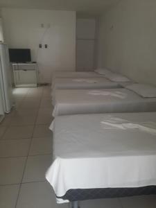 佩森佩塞姆套房旅馆的白色墙壁的房间的一排床位