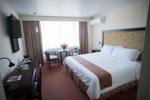 圣萨尔瓦多贝斯特韦斯特普拉斯特拉扎酒店的酒店客房设有一张大床和一张桌子。