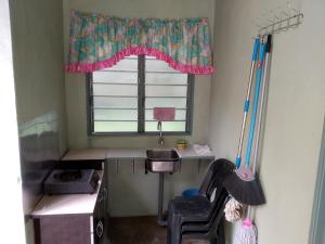 Kampong MerbokDZe Homestay Singkir Genting的客房设有带水槽的窗户和书桌