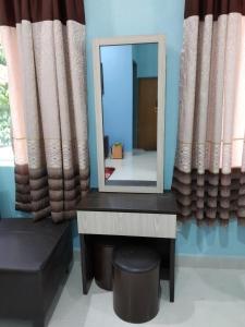 Kampong MerbokDZe Homestay Singkir Genting的一张桌子上的镜子,有窗帘