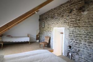 Beyrie-en-BéarnDomaine Lacay的一间石墙卧室和一张位于客房内的床