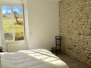 Beyrie-en-BéarnDomaine Lacay的卧室设有砖墙、床和窗户