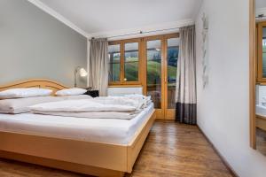 霍赫克尼希山麓丁滕ALMHOF Alpin Apartments & Spa的一间卧室设有两张床和窗户。