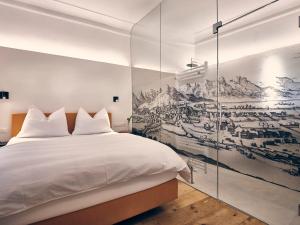 蒂罗尔州霍尔Hotel kontor的卧室配有白色的床和墙上的绘画作品