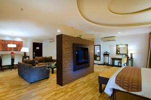 坤甸ASTON Pontianak Hotel and Convention Center的酒店客房设有床和客厅。