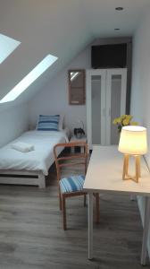 KalwyZacisze Kalwy的客房设有两张床、一张桌子和一盏灯。