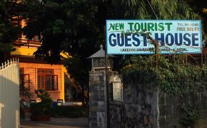 博卡拉新旅者旅馆的房屋前的新旅游旅馆标志