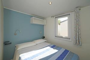 佩斯基耶拉德加达蝴蝶野营村旅馆的一间小卧室,配有床和窗户