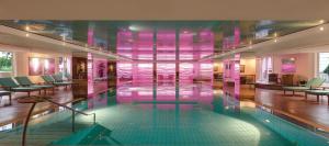 汉堡汉堡爱丽舍酒店的粉红色墙壁的建筑内的游泳池