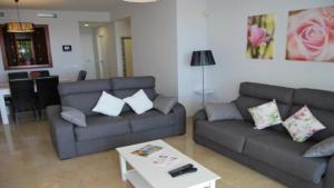 阿尔加德萨Apartamento 6 persona en la Alcaidesa的客厅配有两张沙发和一张咖啡桌