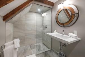 WestportThe Victorian Luxury Suites的带淋浴、盥洗盆和镜子的浴室