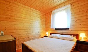 鲁斯诺沃Domki u Małgosi的小木屋内一间卧室,配有一张床
