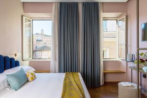 罗马Condominio Monti Boutique Hotel的酒店客房设有一张床和两个窗户。