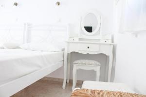 伊奥斯乔拉伊奥斯蓝色地平线公寓 的白色卧室配有梳妆台和镜子