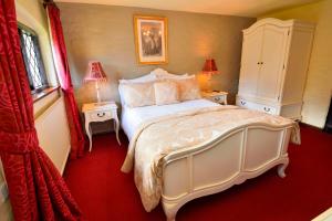 普尔伯勒环岛酒店的卧室配有一张白色的大床和两张桌子