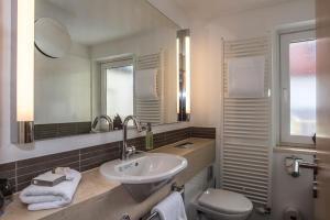 慕尼黑巴伐利亚精品酒店的一间带水槽、卫生间和镜子的浴室