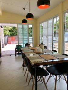 宋卡Ban Soi San Sook Homestay的用餐室配有长木桌子和椅子