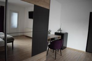 克卢日-纳波卡Bruno Apartment的一间卧室配有一张桌子和一张紫色椅子