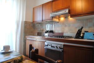 罗镇Bnbook-Costantino的厨房配有木制橱柜和炉灶。