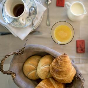 Gingelom卡梅丽杰克住宿加早餐旅馆的一篮羊角面包和一杯咖啡在桌子上