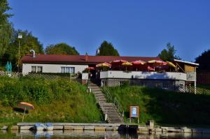 霍赫菲希特山麓克拉弗尔Mobilheime的河边一座带楼梯和遮阳伞的建筑