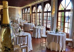 科尔特弗兰卡黎莱斯佛兰切柯尔塔酒店的配有桌椅和白色桌子及窗户的房间