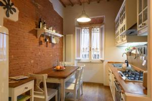 阿雷佐In Arezzo Apartment的厨房配有木桌和砖墙