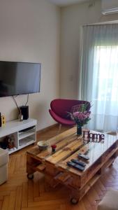 布宜诺斯艾利斯阿根廷巴勒莫公寓的客厅配有咖啡桌和平面电视。