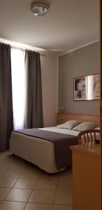 比萨阿斯特酒店的一间卧室设有一张大床和一个窗户。