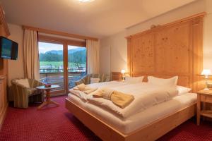 莱赫阿尔贝格美丽达豪斯酒店的一间卧室设有一张大床和一个大窗户