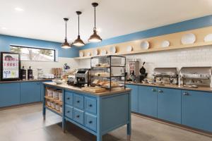 贝尔维尔Country Inn & Suites by Radisson, Belleville, ON的厨房配有蓝色橱柜和食品柜台。