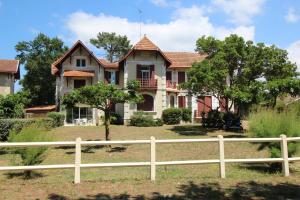 安德诺莱斯贝恩Appartement 2 chambres Bassin d'Arcachon front de mer, plage du Betey的前面有围栏的房子