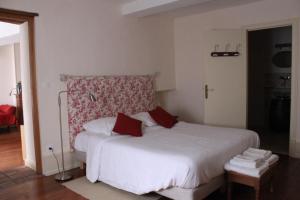 韦兹莱Cellier de l'abbaye - L'Ermitage的卧室配有带红色枕头的大型白色床