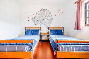 阿尔图拉Altura Inn Cottage的两张床位于带雨伞的墙上。