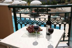 拉加纳斯Timos Hotel的一张桌子,上面放着两杯葡萄酒和葡萄