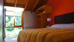 拉安戈斯图拉镇ROSALES Alojamiento的一间卧室配有一张带橙色墙壁和窗户的床。