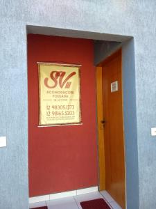 陶巴特Acomodações Silvestre的门旁有标志的红色墙