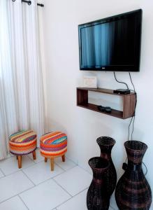 陶巴特Acomodações Silvestre的客厅配有2瓶花和1台电视