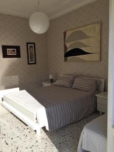 切齐纳码头Appartamento Acquamarina的卧室配有一张床,墙上挂有绘画作品